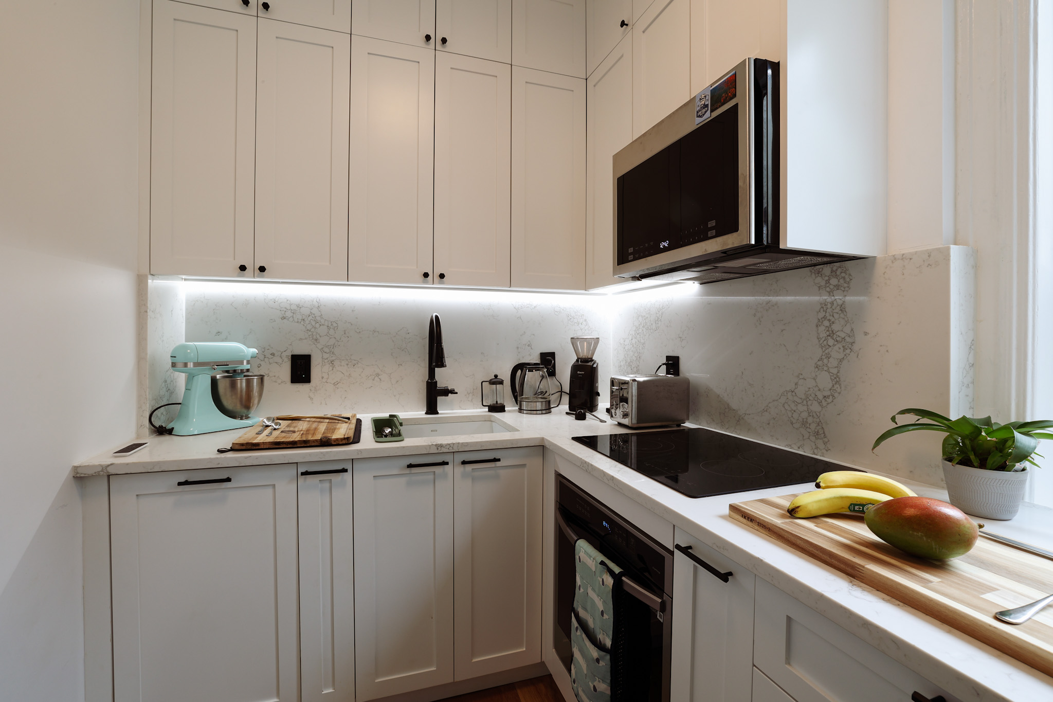 Kitchen corner — L-layout with marble-look quartz and LED lighting